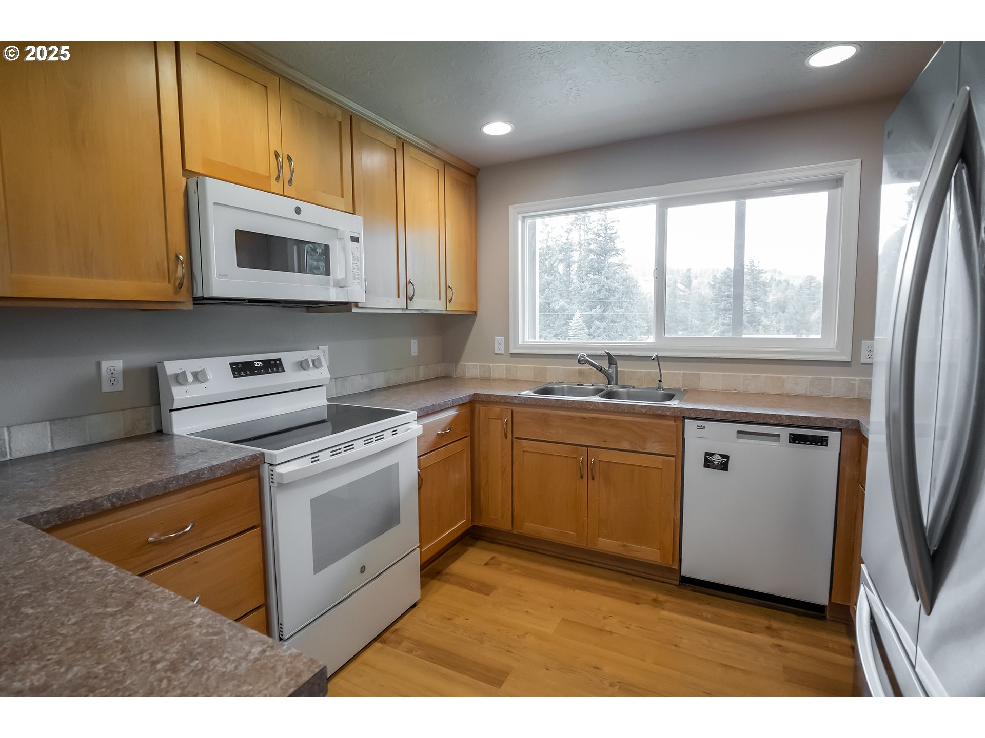76377 Mosby Creek Road Cottage Grove, OR 97424 - Photo 6 of 48 a kitchen with stainless steel appliances granite countertop a stove a sink and a microwave