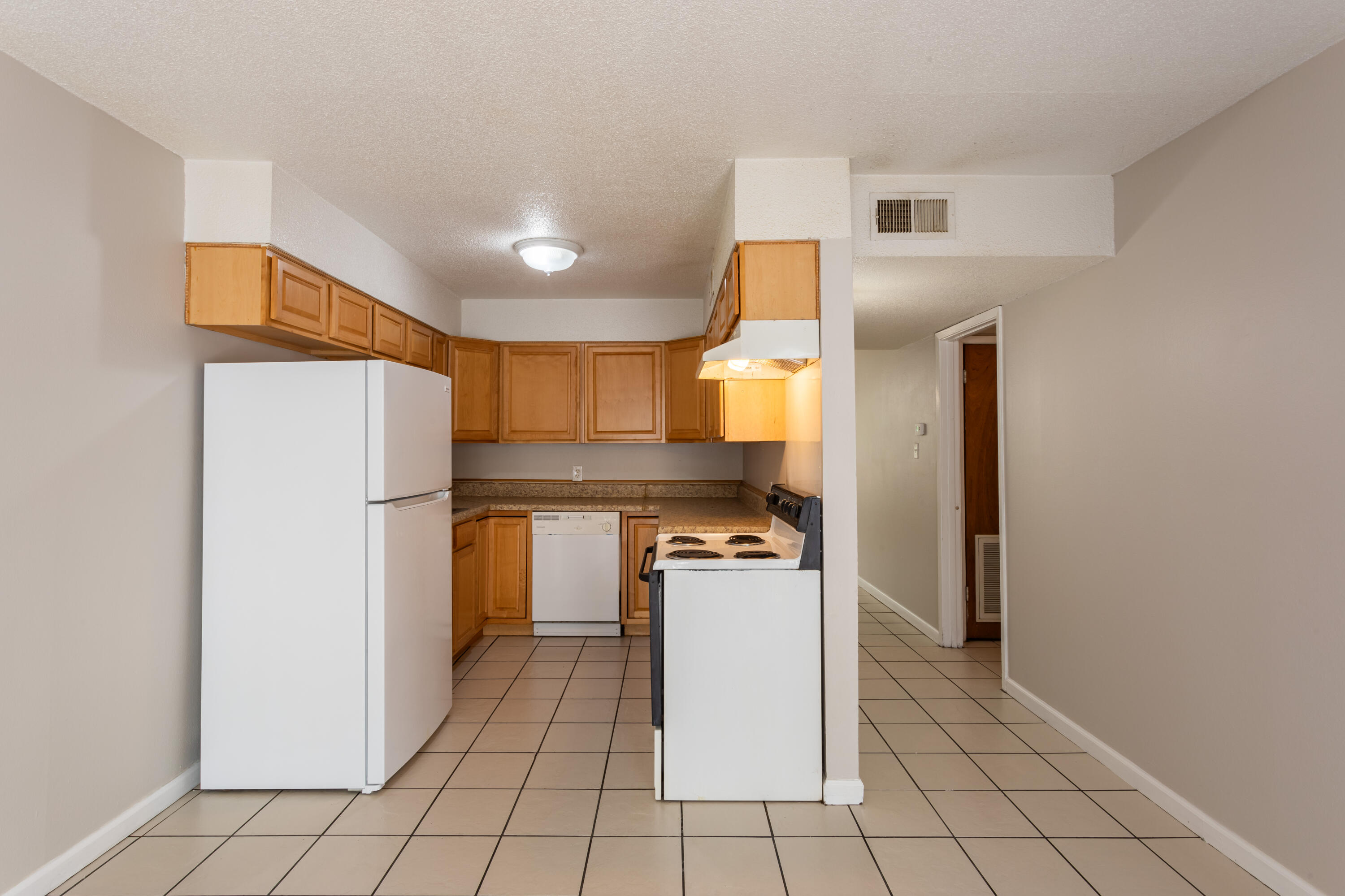 210 Pelham Road, Unit 209A Fort Walton Beach, FL 32547 - Photo 7 of 19 a kitchen with a refrigerator a stove top oven and cabinets