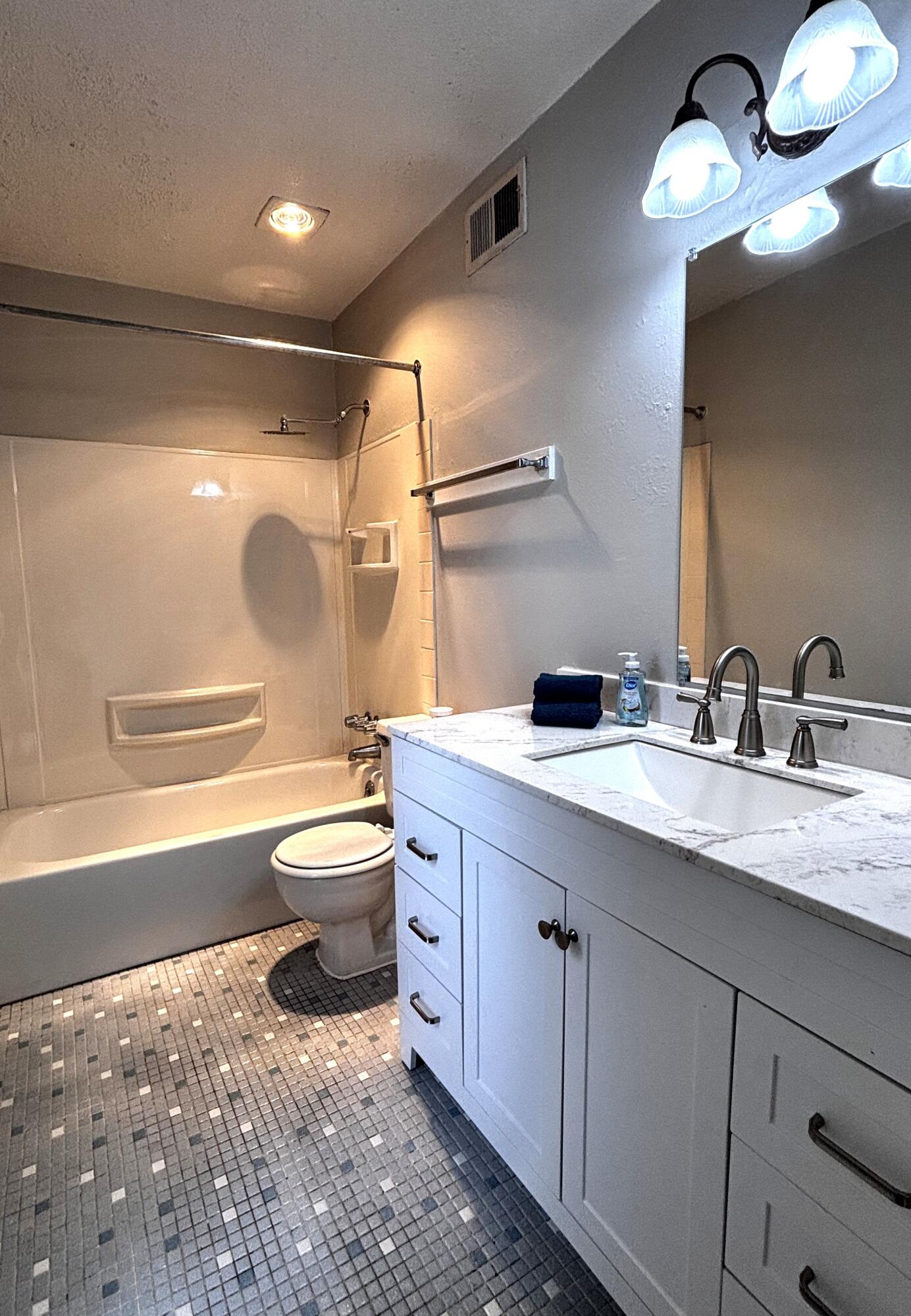 210 Pelham Road, Unit 209A Fort Walton Beach, FL 32547 - Photo 9 of 19 a bathroom with a toilet a sink and a mirror