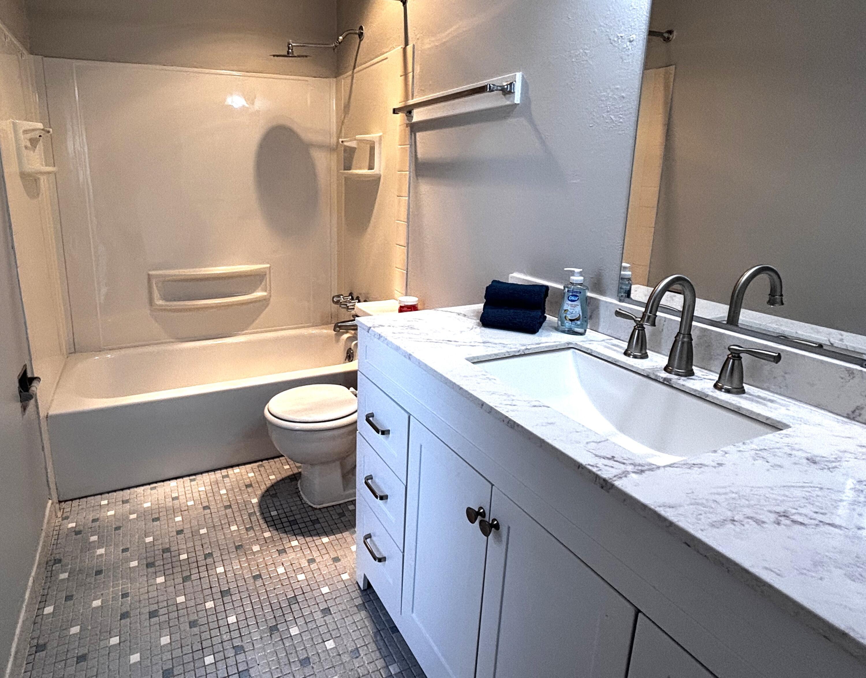 210 Pelham Road, Unit 209A Fort Walton Beach, FL 32547 - Photo 10 of 19 a bathroom with a granite countertop sink a toilet a mirror and shower