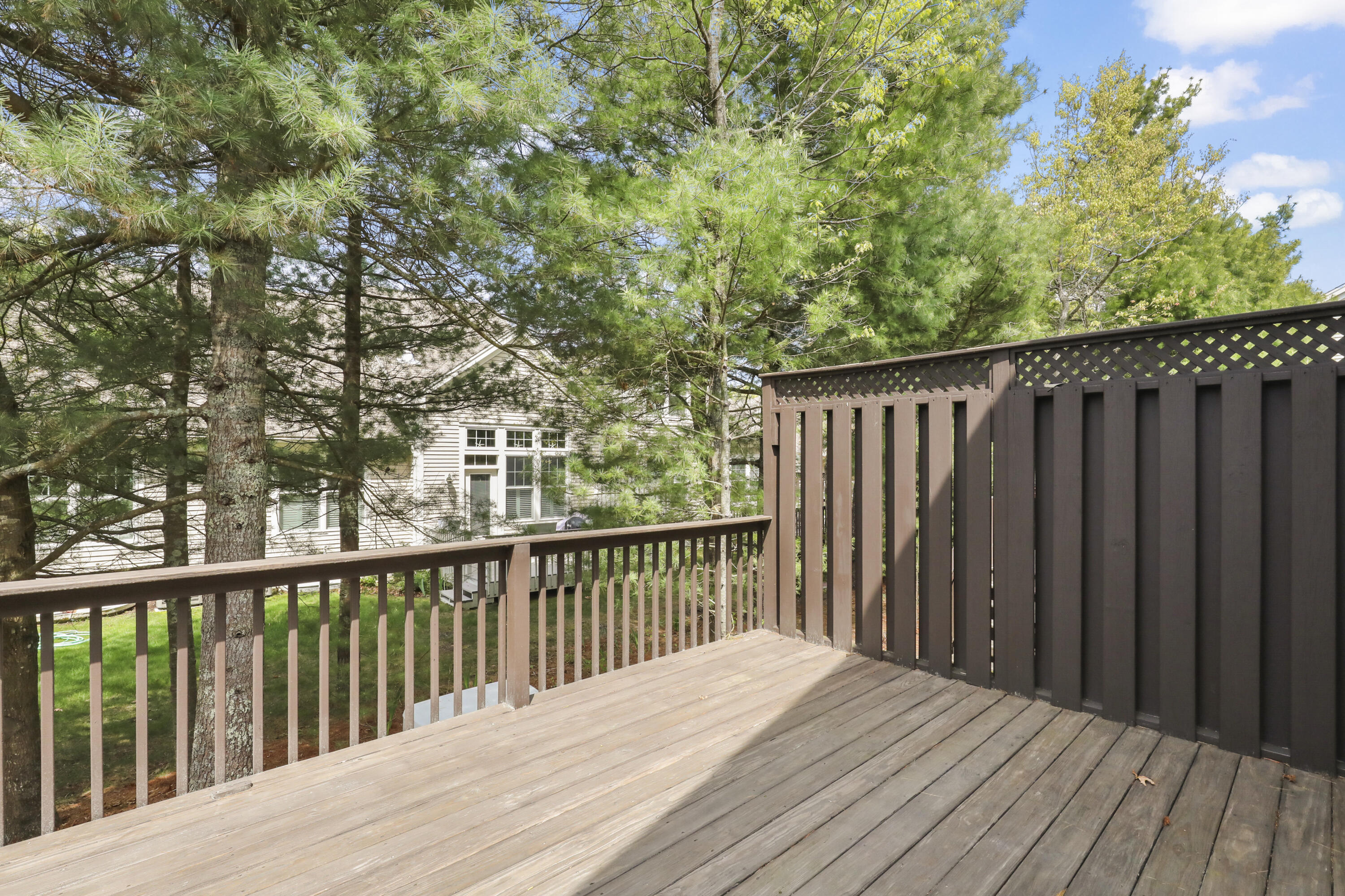 21 Grey Hawk Drive, Unit 21 Mashpee, MA 02649 - Photo 24 of 34 a balcony with wooden floor and fence