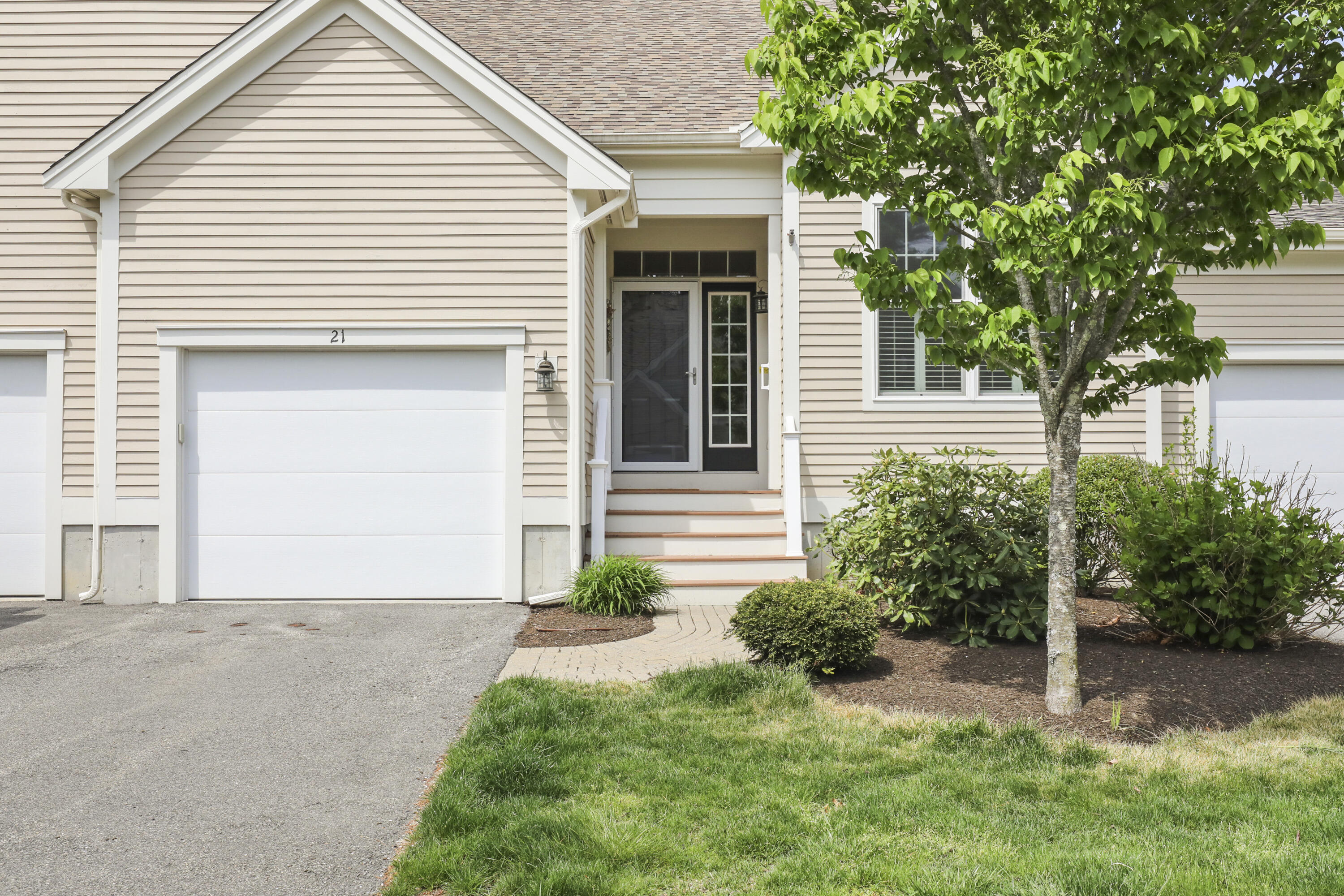 21 Grey Hawk Drive, Unit 21 Mashpee, MA 02649 - Photo 28 of 34 a front view of a house with a yard and garage