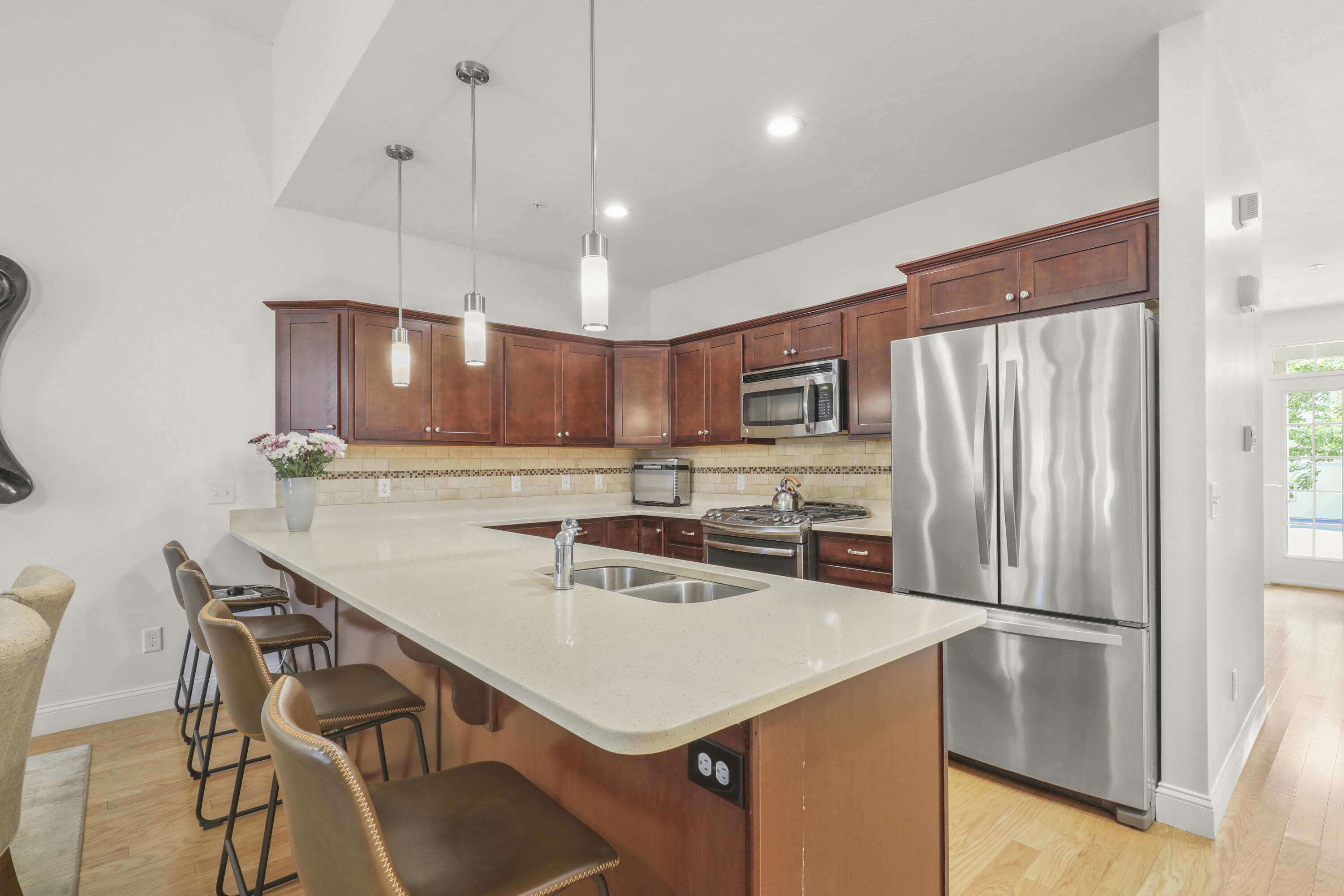 21 Grey Hawk Drive, Unit 21 Mashpee, MA 02649 - Photo 5 of 34 a kitchen with a refrigerator a sink and chairs