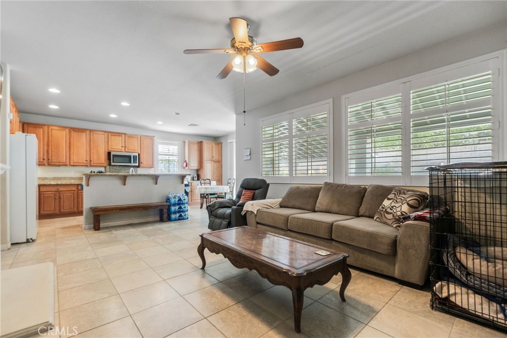 6136 Walnut Grove Court Rancho Cucamonga, CA 91739 - Photo 13 of 41 a living room with furniture and a large window with kitchen view