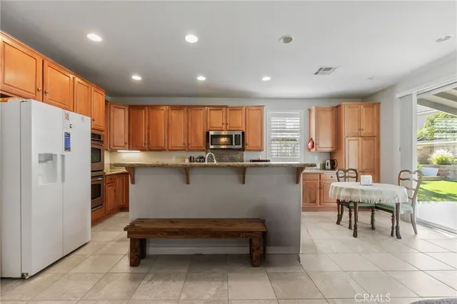 a kitchen with a refrigerator a table and chairs