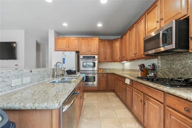 a kitchen with stainless steel appliances granite countertop a sink and a stove