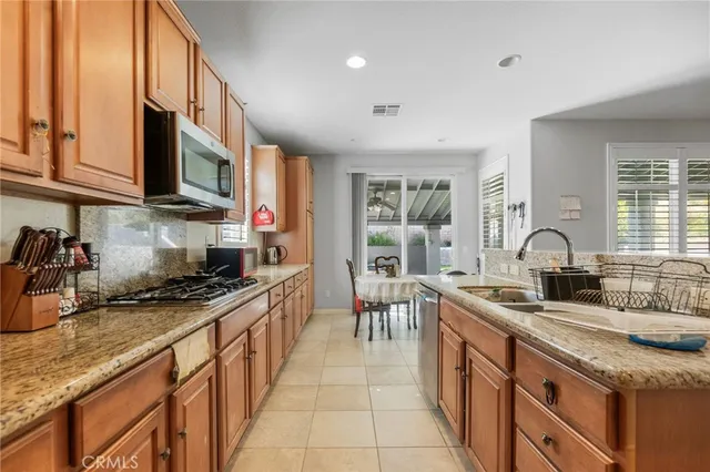 a kitchen with stainless steel appliances granite countertop a sink stove and cabinets