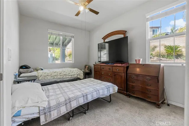 a bedroom with a bed and a flat tv screen on dresser
