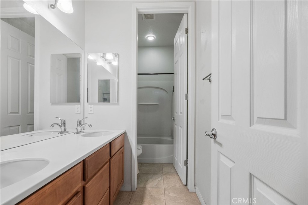 6136 Walnut Grove Court Rancho Cucamonga, CA 91739 - Photo 32 of 41 a bathroom with a double vanity sink a toilet and shower