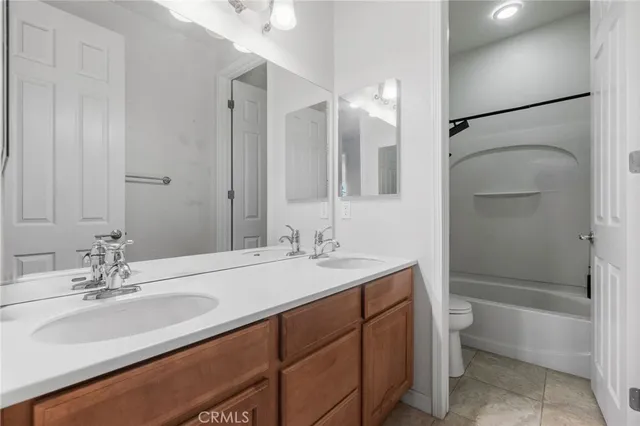 a bathroom with a sink double vanity granite tub and shower