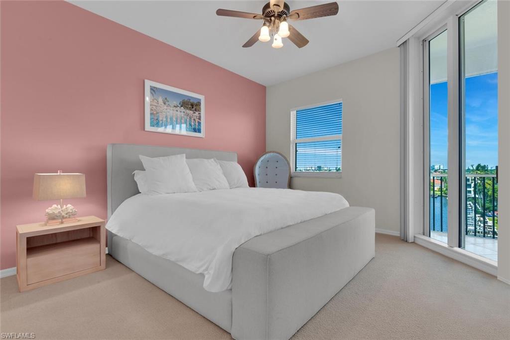 450 Launch Circle, Unit 602 Naples, FL 34108 - Photo 11 of 27 a bedroom with a bed and a chandelier