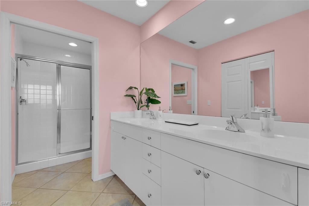 450 Launch Circle, Unit 602 Naples, FL 34108 - Photo 13 of 27 a bathroom with a granite countertop sink a mirror and a shower
