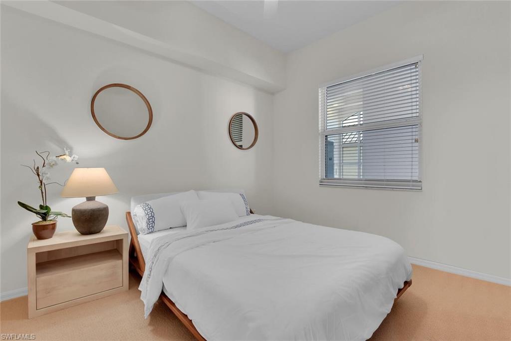 450 Launch Circle, Unit 602 Naples, FL 34108 - Photo 17 of 27 a bedroom with a bed and cabinets