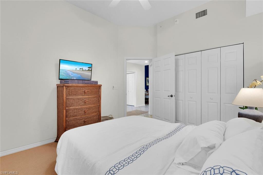 450 Launch Circle, Unit 602 Naples, FL 34108 - Photo 18 of 27 a bedroom with a bed and a closet