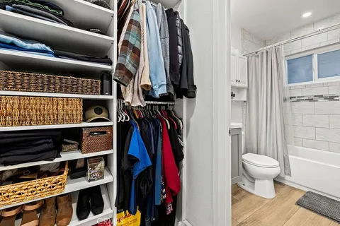 a view of walk in closet with clothes and shoes