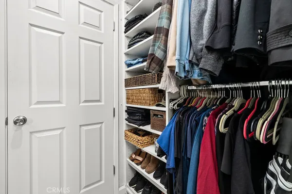 a view of walk in closet with clothes and shoes