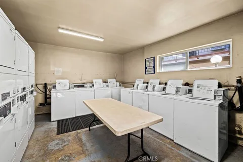 a kitchen with stainless steel appliances a table and chairs in it