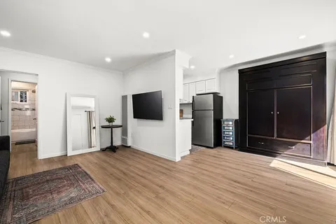 a view of a livingroom with a flat screen tv wooden floor and closet