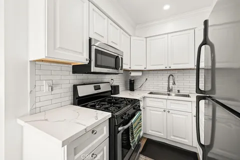 a kitchen with cabinets appliances a sink and a counter top