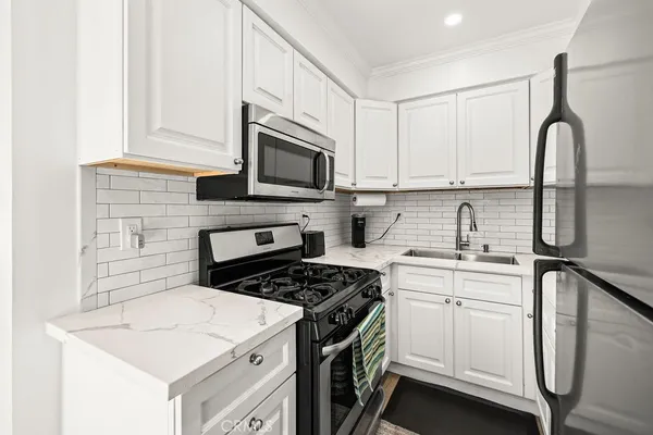 a kitchen with cabinets appliances a sink and a counter top