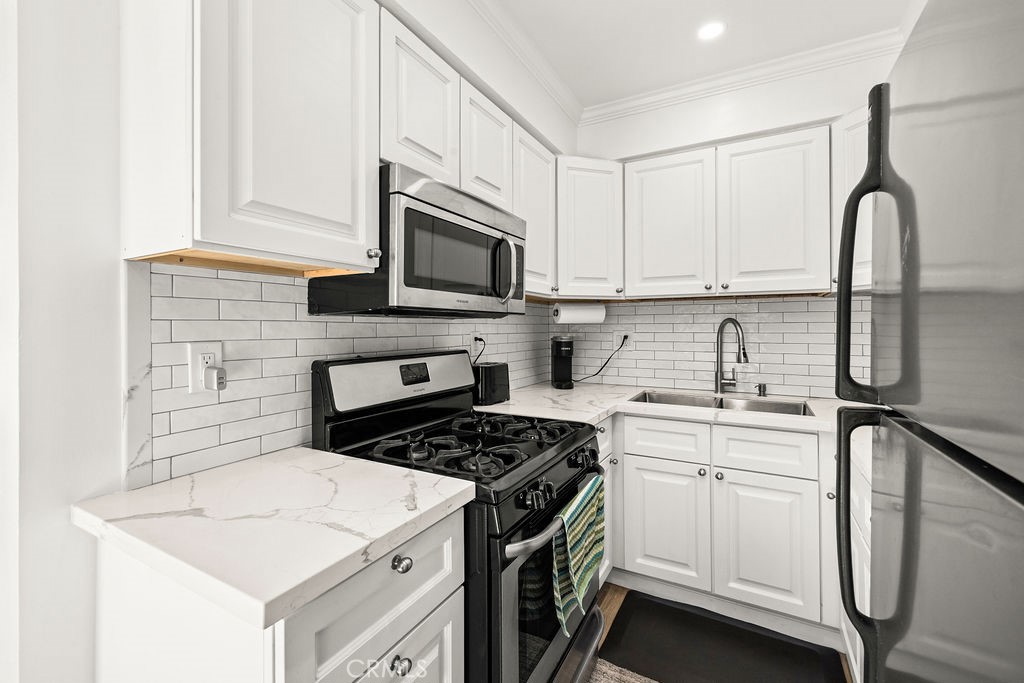5050 Linden Avenue, Unit 62 Long Beach, CA 90805 - Photo 6 of 37 a kitchen with cabinets appliances a sink and a counter top