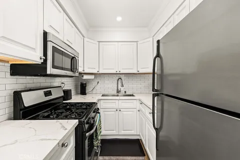 a kitchen with stainless steel appliances a stove microwave and sink