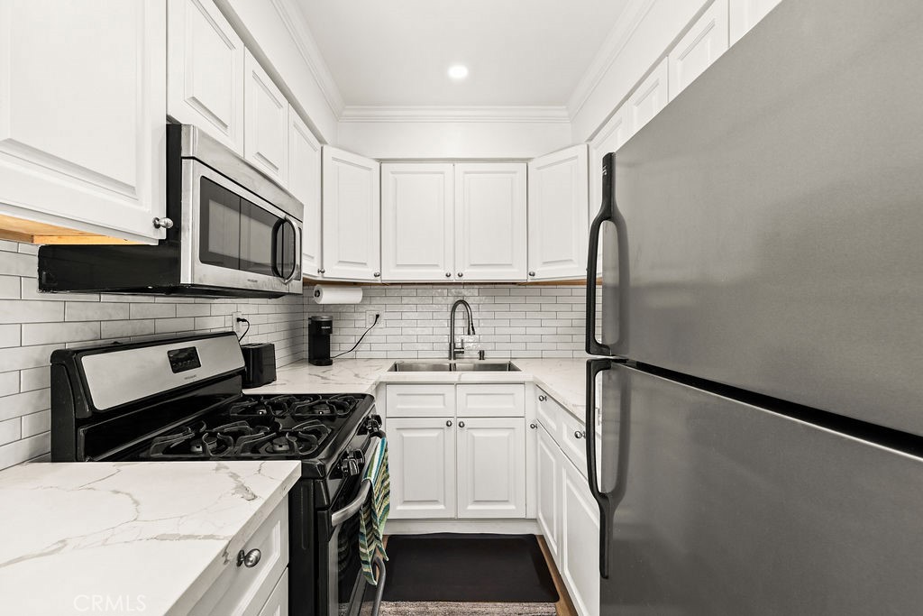 5050 Linden Avenue, Unit 62 Long Beach, CA 90805 - Photo 7 of 37 a kitchen with stainless steel appliances a stove microwave and sink