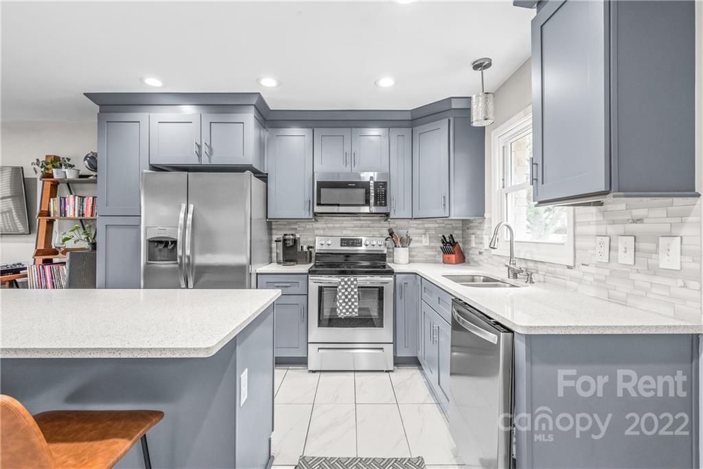 3932 Slagle Drive Charlotte, NC 28215 - Photo 12 of 26 a kitchen with stainless steel appliances granite countertop a sink stove and refrigerator