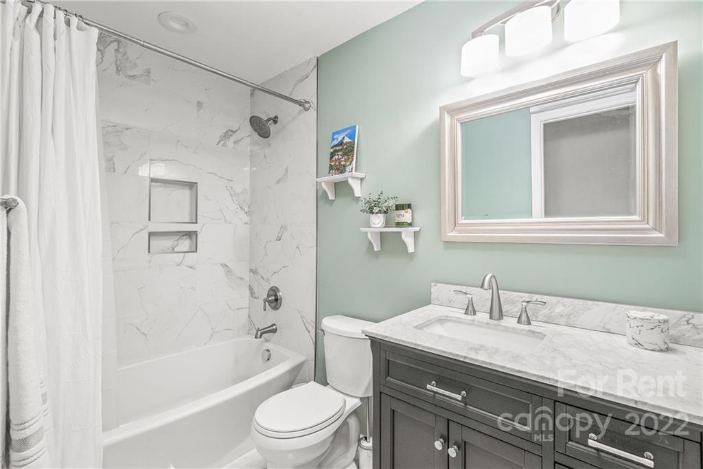 3932 Slagle Drive Charlotte, NC 28215 - Photo 17 of 26 a bathroom with a granite countertop sink a toilet and shower