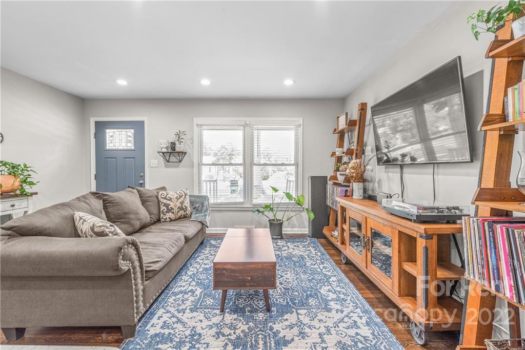 3932 Slagle Drive Charlotte, NC 28215 - Photo 9 of 26 a living room with furniture a flat screen tv and a floor to ceiling window