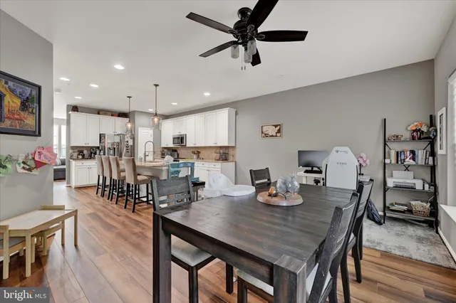 a kitchen with a dining table chairs stainless steel appliances and cabinets