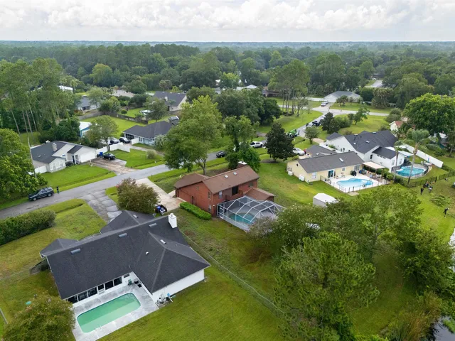a view of a house with a yard and potted plants
