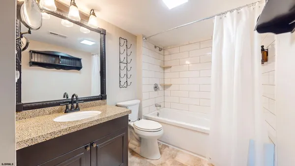 a bathroom with a granite countertop sink toilet a shower and a mirror