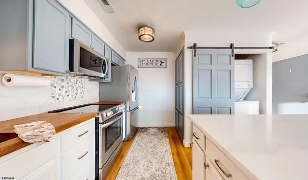 a kitchen with stainless steel appliances granite countertop a lot of counter space and wooden floor