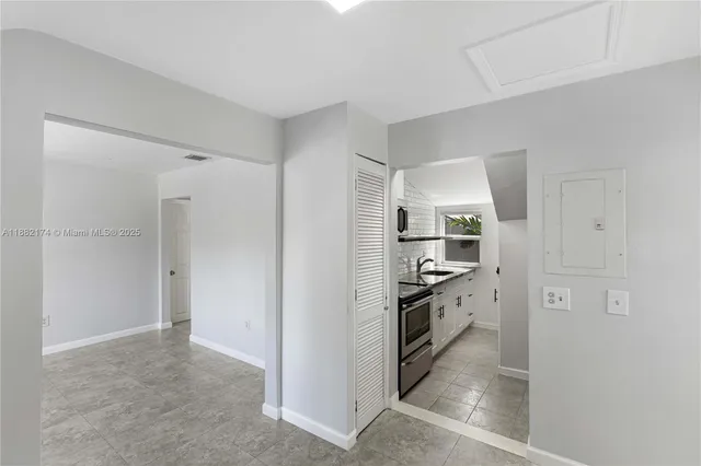 a view of kitchen with refrigerator and cabinets