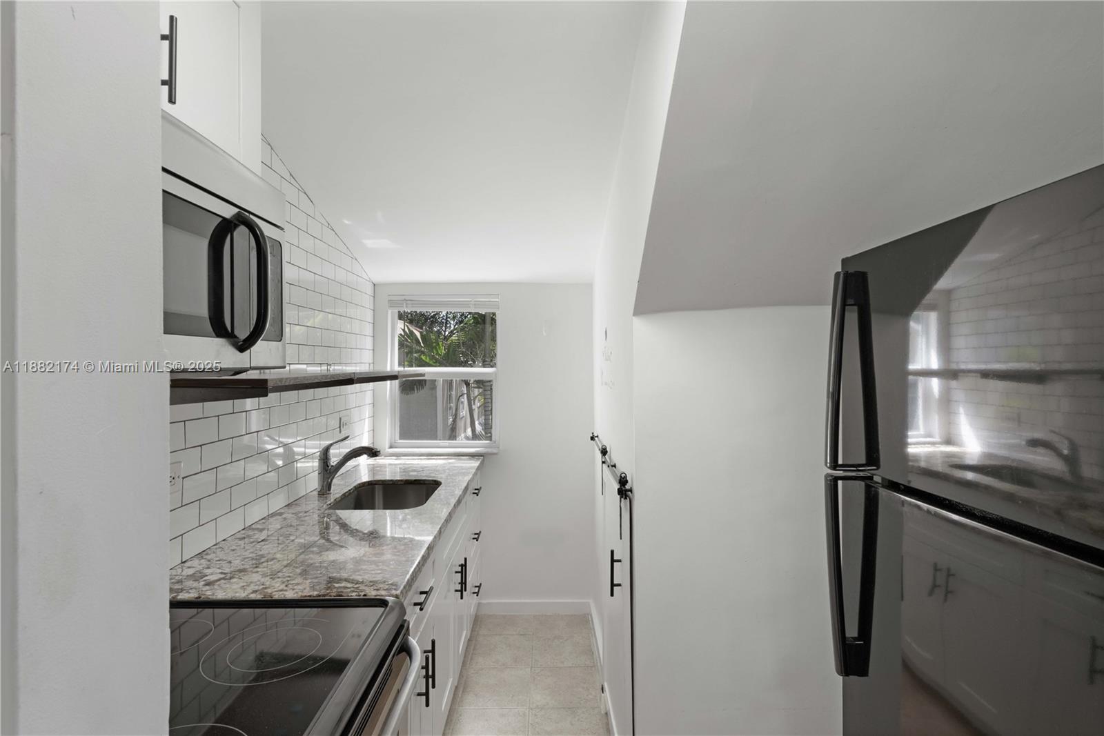 1408 Southwest 19th Terrace, Unit 1410 Miami, FL 33145 - Photo 4 of 12 a kitchen with kitchen island a counter top space appliances and a counter top space