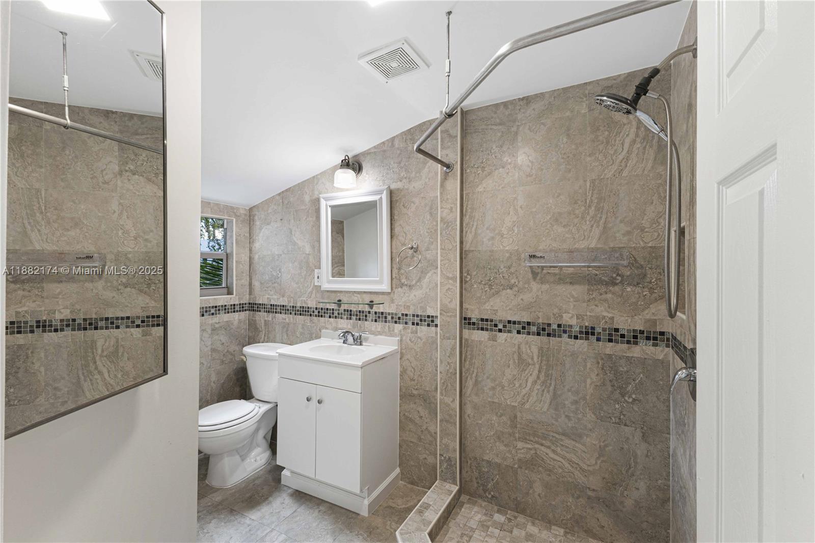 1408 Southwest 19th Terrace, Unit 1410 Miami, FL 33145 - Photo 9 of 12 a bathroom with a granite countertop shower a toilet and sink