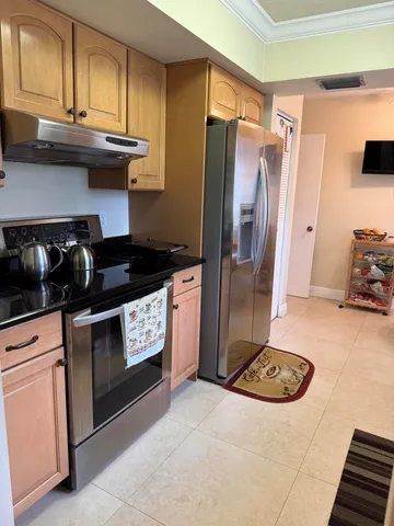 a kitchen with stainless steel appliances granite countertop a refrigerator a stove and a sink