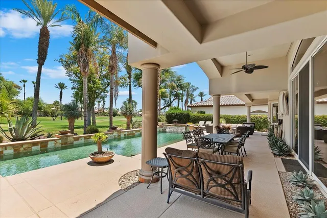 a view of swimming pool with chairs and yard