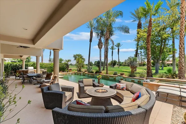 a view of a house with backyard sitting area and swimming pool