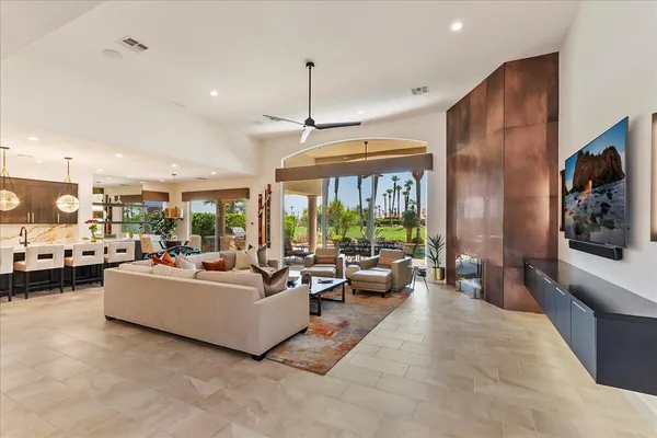 a living room with furniture a table and a large window