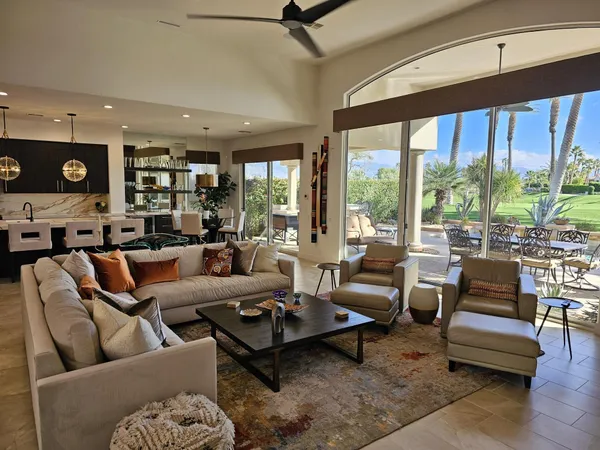 a living room with furniture and floor to ceiling windows