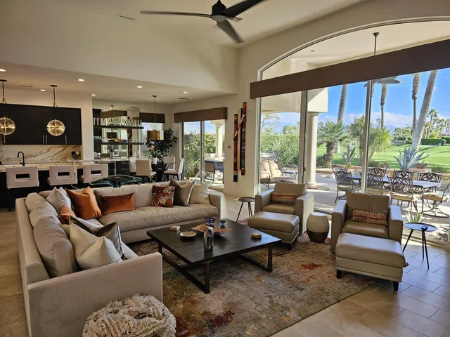 a living room with furniture and floor to ceiling windows