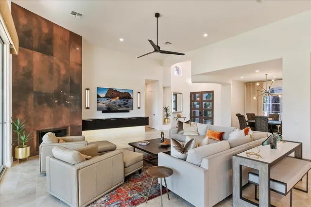 a living room with furniture kitchen view and a large window