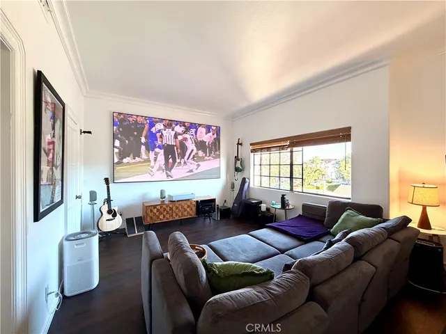 a living room with furniture a window and a flat screen tv
