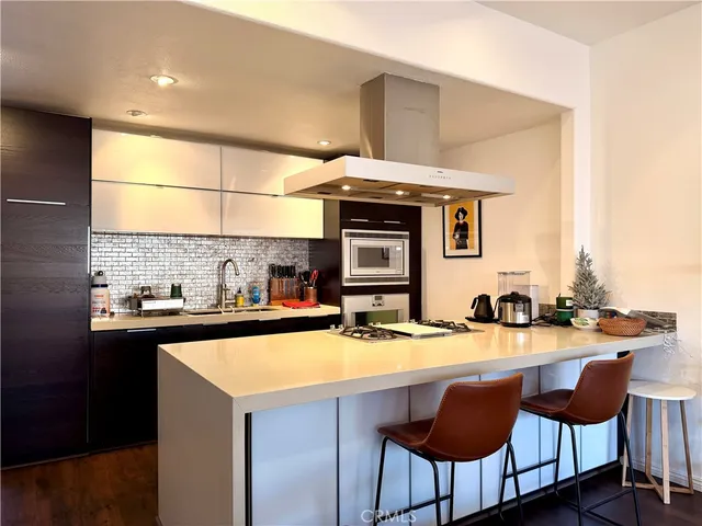 a kitchen with a sink a stove and chairs