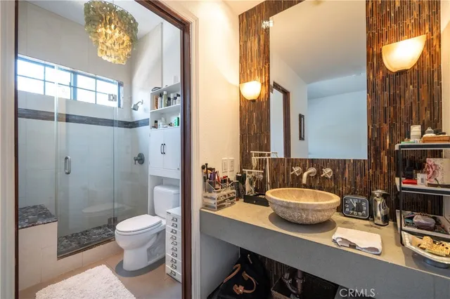 a bathroom with a sink a toilet and shower