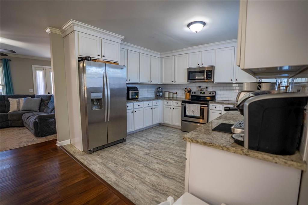 707 Reese Street Monroe, GA 30655 - Photo 18 of 61 a kitchen with stainless steel appliances granite countertop a refrigerator a stove a sink and a granite counter tops with wooden floors