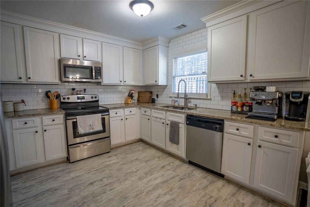 707 Reese Street Monroe, GA 30655 - Photo 19 of 61 a kitchen with white cabinets sink and appliances