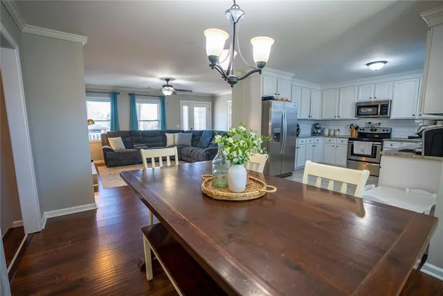 a view of a dining room with furniture a chandelier and wooden floor